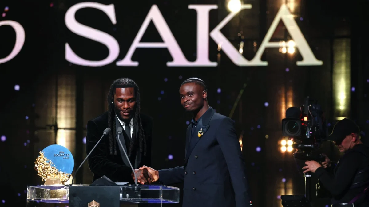 Burna Boy presents the Socrates Award to Bukayo Saka on stage at the 2026 Ballon d’Or ceremony in London